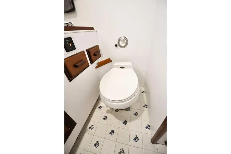 Slide: The Image of 1987 Jarvis Newman 46' Flybridge Cruiser bathroom with white toilet and floral tile flooring. - 59