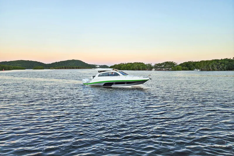 Slide: The Image of 2026 Hanover 375 boat cruising on a serene lake at sunset. - 3