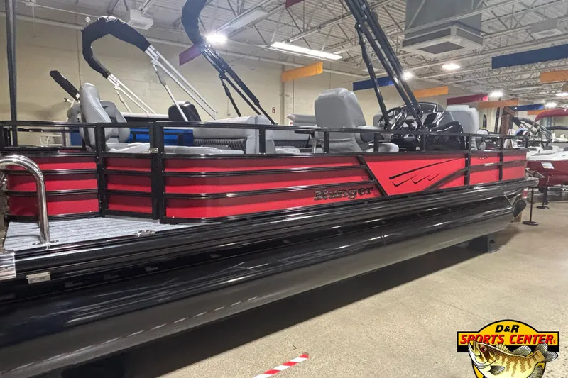 Slide: The Image of 2026 Ranger Reata 220F pontoon boat in showroom, featuring red and black design. - 1