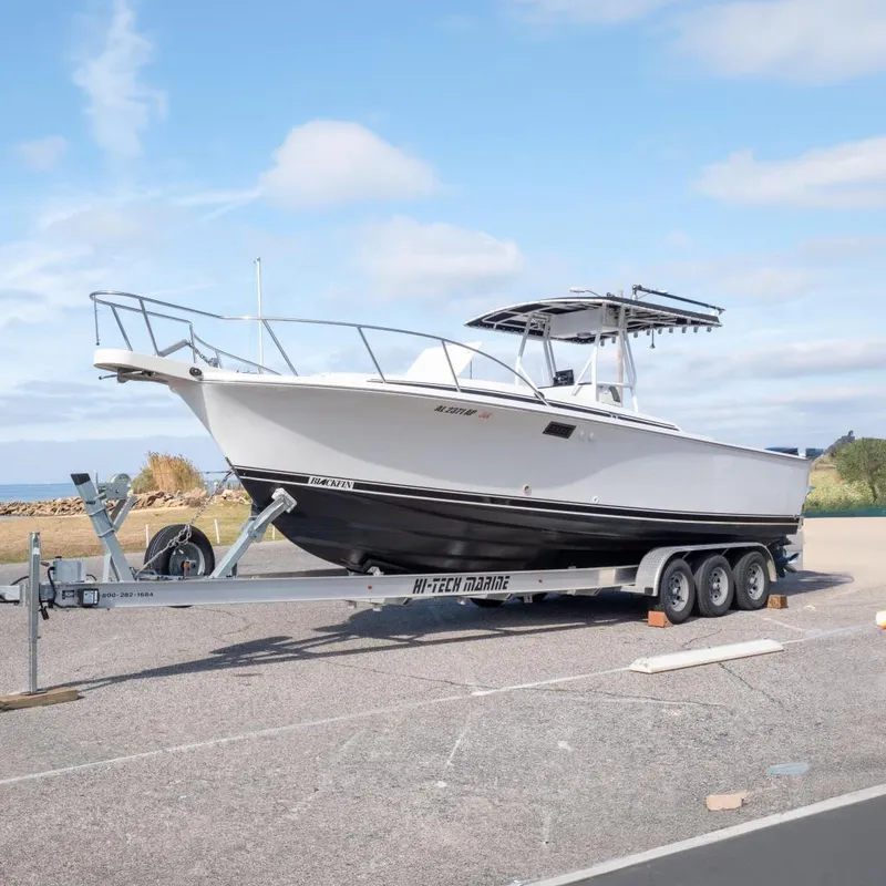 The Image of 1989 Blackfin 272 CC boat on trailer, blue sky. - 0