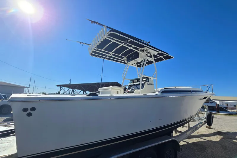 Slide: The Image of 1989 Blackfin 272 CC boat on trailer under clear blue sky. - 3
