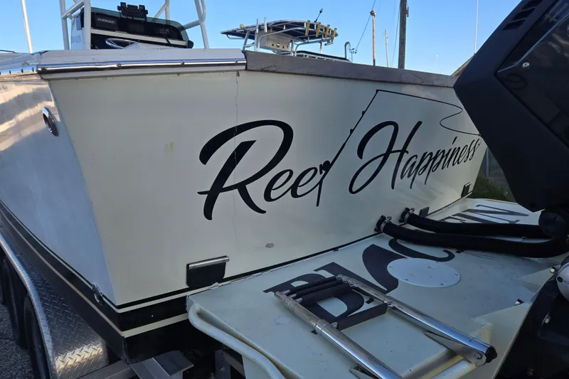 Slide: The Image of 1989 Blackfin 272 CC boat with "Reef Happiness" text on the side. - 4