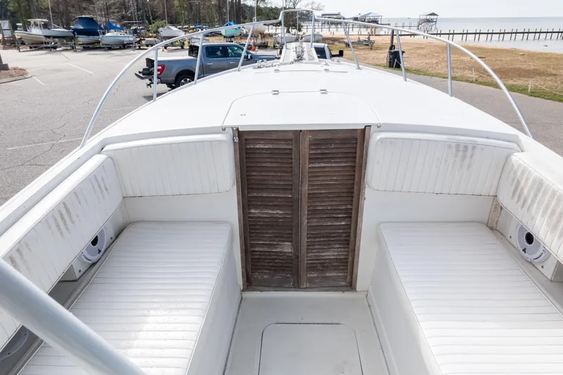 Slide: The Image of 1989 Blackfin 272 CC boat interior with white seating and wooden door. - 7