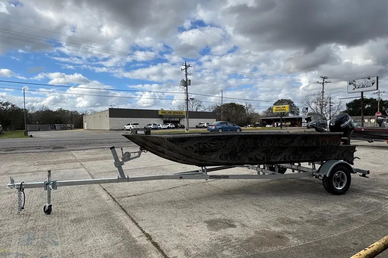 The Image of 2026 SeaArk 1752 Slayer X Pro boat on trailer, parked outdoors under cloudy sky. - 1