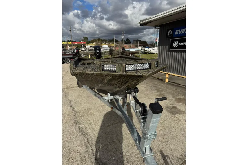 Slide: The Image of 2026 SeaArk 1752 Slayer X Pro boat on trailer, camo design, outdoor setting. - 4