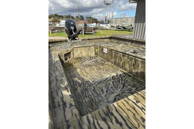 Slide: The Image of 2026 SeaArk 1752 Slayer X Pro boat with camouflage design and outboard motor. - 7