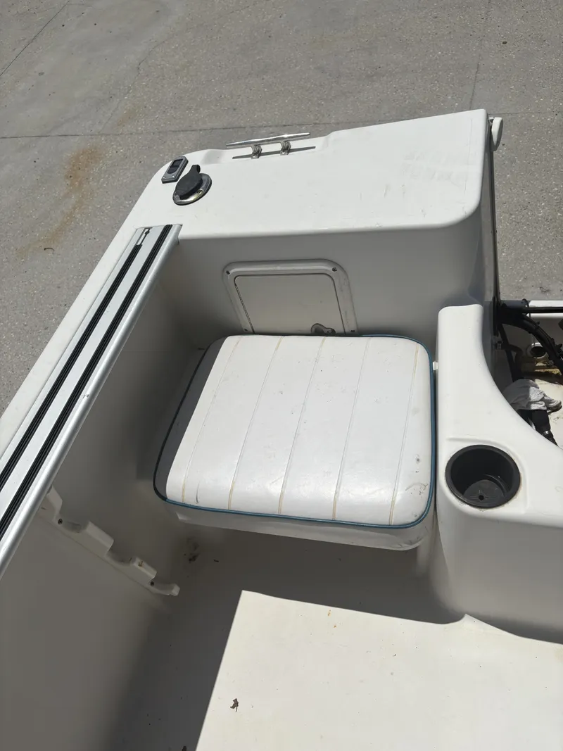 Slide: The Image of 1996 Pro-Line 202 boat interior with white seating and storage compartment. - 13