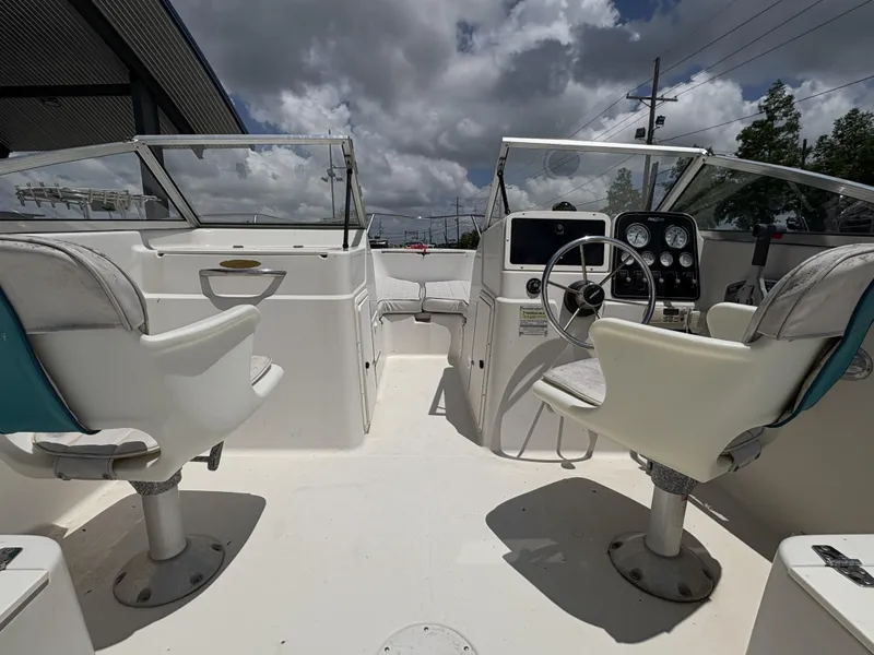 Slide: The Image of 1996 Pro-Line 202 boat interior with dual seats, steering wheel, and dashboard under cloudy sky. - 5