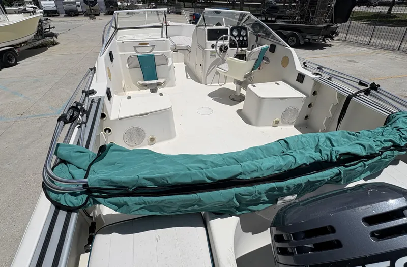 Slide: The Image of 1996 Pro-Line 202 boat interior with seating and steering console, docked outdoors. - 9