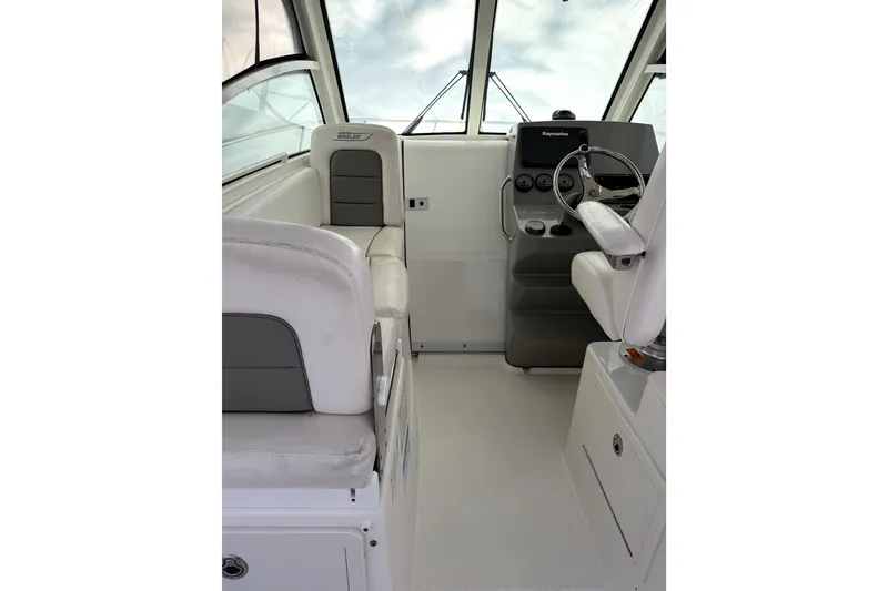 Slide: The Image of Interior of 2014 Boston Whaler 285 Conquest boat, featuring helm and seating area. - 13