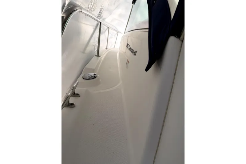 Slide: The Image of 2014 Boston Whaler 285 Conquest boat deck with railing and logo visible. - 15
