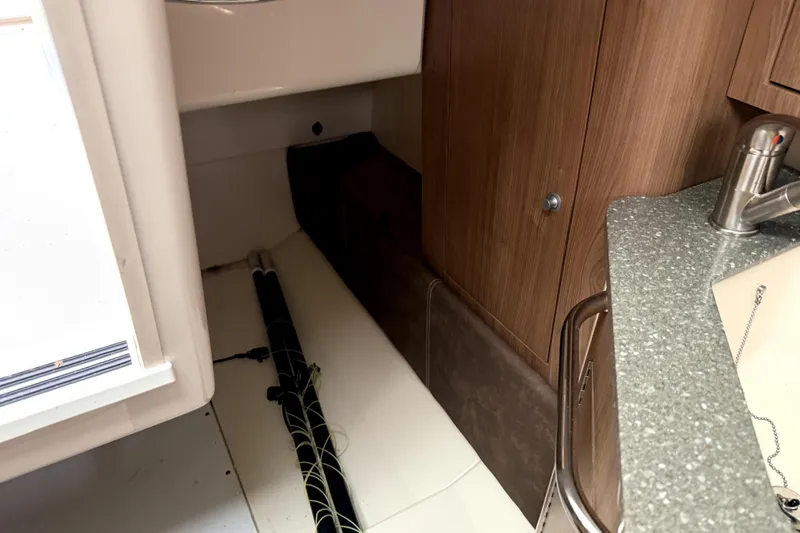 Slide: The Image of Interior of 2014 Boston Whaler 285 Conquest, featuring wood cabinetry and countertop. - 17