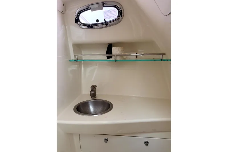 Slide: The Image of 2014 Boston Whaler 285 Conquest bathroom sink with shelf and porthole window. - 22