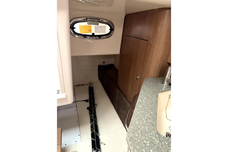 Slide: The Image of Interior of 2014 Boston Whaler 285 Conquest boat, featuring wood cabinetry and compact design. - 25
