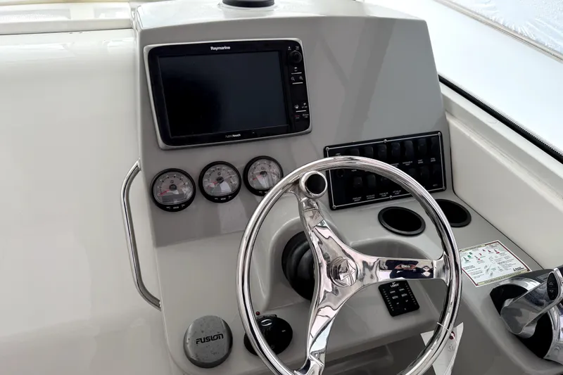 Slide: The Image of 2014 Boston Whaler 285 Conquest helm with steering wheel and navigation controls. - 5