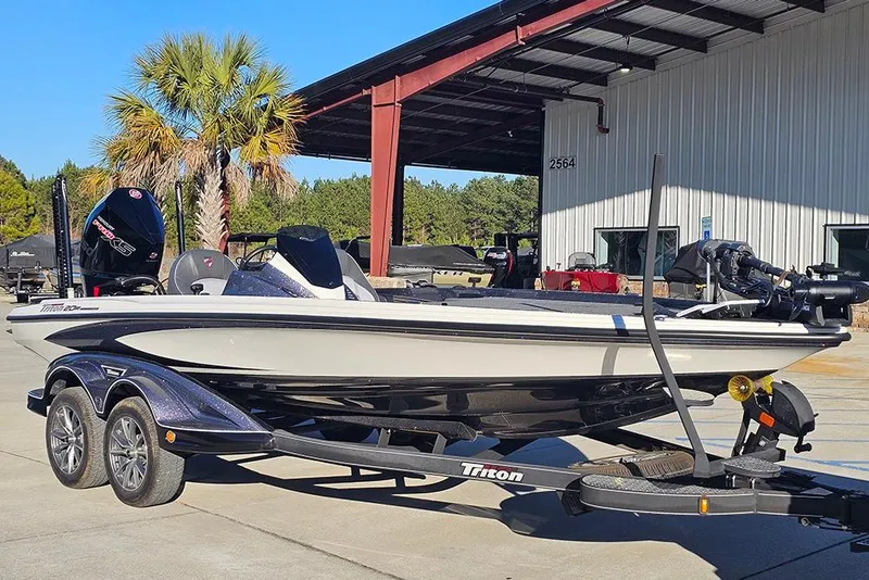 Slide: The Image of 2026 Triton 20XP Patriot boat on trailer outside dealership. - 2