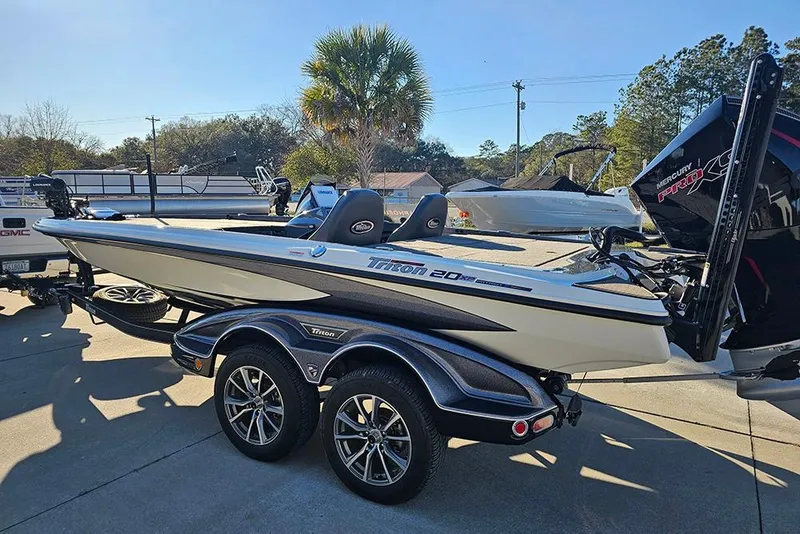 Slide: The Image of 2026 Triton 20XP Patriot boat with powerful outboard motor, parked outdoors. - 7