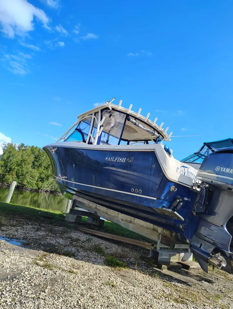 Slide: The Image of Sailfish 325 Dual Console boat, 2017, on land, blue sky. - 6