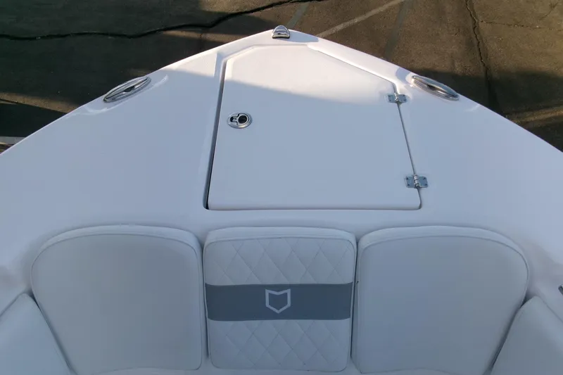 Slide: The Image of 2026 Sea Fox 288 Commander boat bow with white cushioned seating and storage hatch. - 4