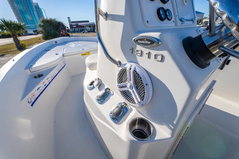 Slide: The Image of 2011 NauticStar 1910 NauticBay boat dashboard with steering wheel and gauges, parked on roadside. - 14