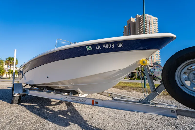 Slide: The Image of 2011 NauticStar 1910 NauticBay boat on trailer, urban background, clear blue sky. - 26