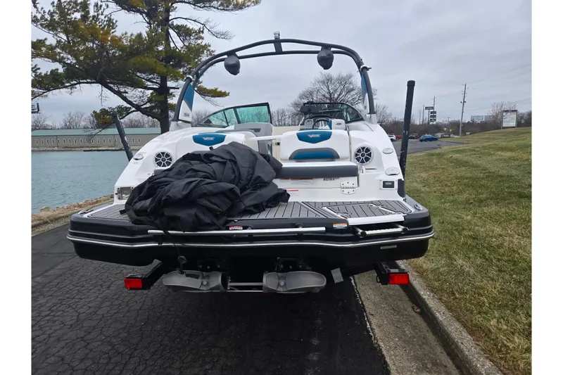 Slide: The Image of 2016 Chaparral Vortex 243 VRX boat parked near a lake on a cloudy day. - 2