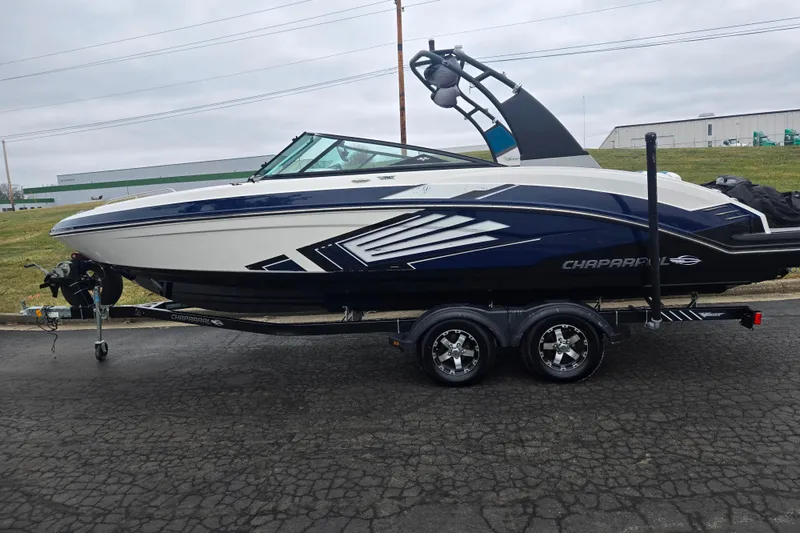 Slide: The Image of 2016 Chaparral Vortex 243 VRX boat on trailer, sleek design, parked outdoors. - 4