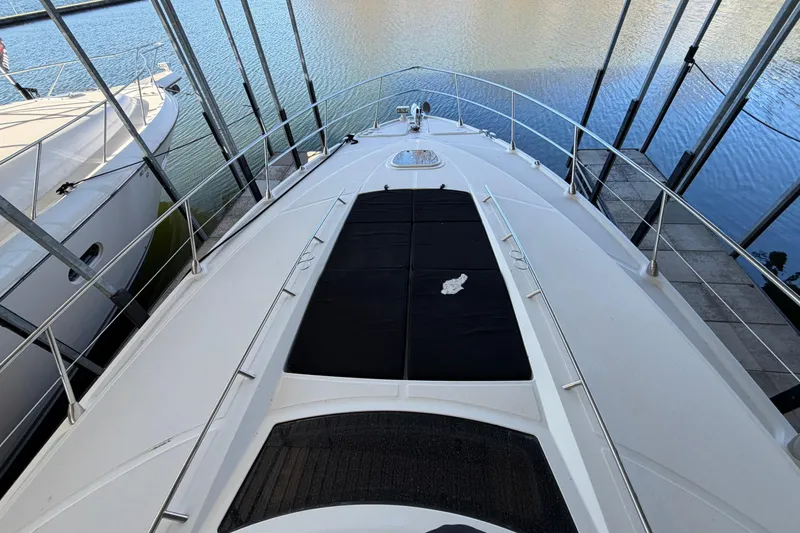 Slide: The Image of 2014 Sea Ray 540 Sundancer yacht docked, showcasing sleek deck design and water view. - 14