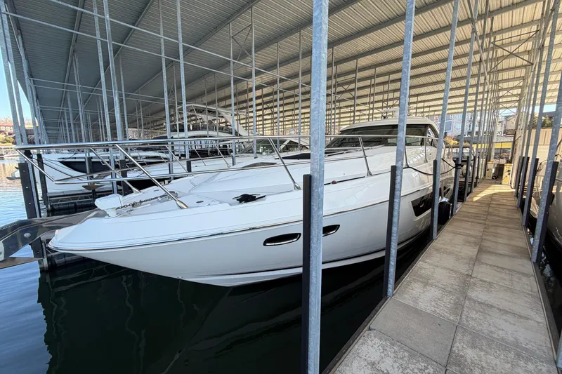 Slide: The Image of 2014 Sea Ray 540 Sundancer yacht docked in a covered marina. - 2