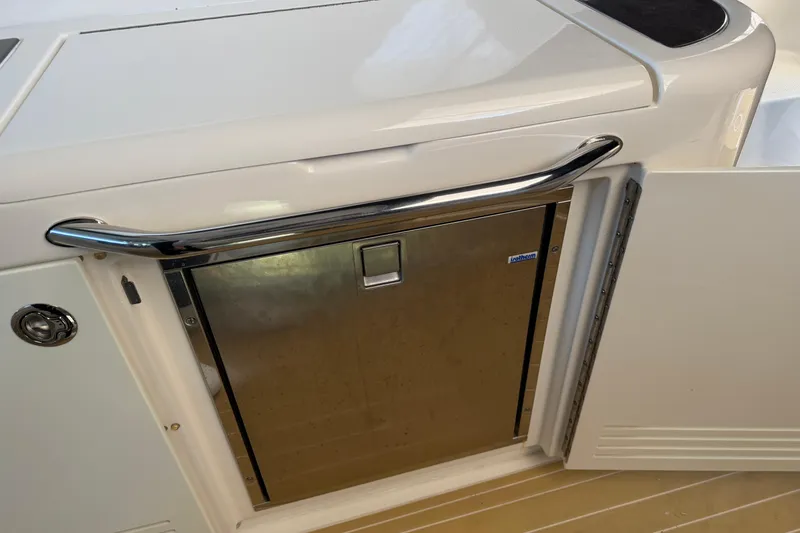 Slide: The Image of 2014 Sea Ray 540 Sundancer yacht interior with stainless steel appliance and open cabinet door. - 41