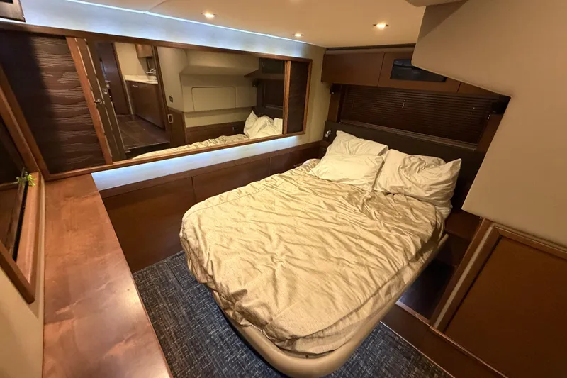 Slide: The Image of Luxurious cabin interior of 2014 Sea Ray 540 Sundancer yacht with cozy bed and wood finishes. - 48