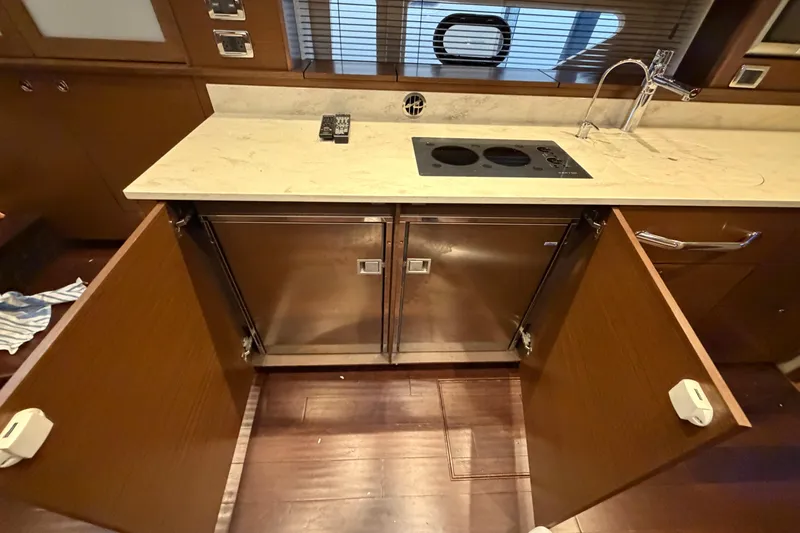 Slide: The Image of Kitchen area of 2014 Sea Ray 540 Sundancer yacht with open cabinets and stove. - 59