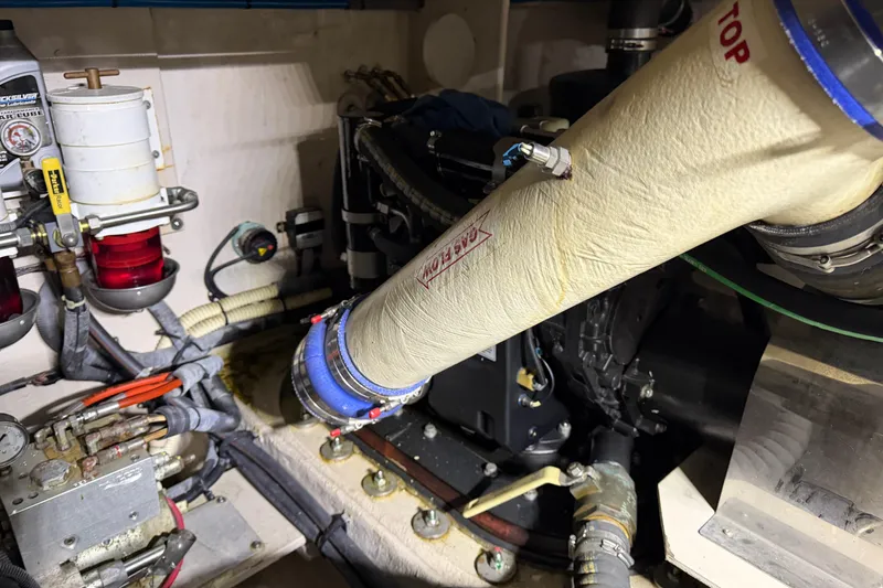 Slide: The Image of Engine room of 2014 Sea Ray 540 Sundancer, showcasing mechanical components and piping. - 73