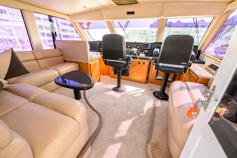 Slide: The Image of Luxurious interior of a 1997 Viking 58 Enclosed Bridge yacht with plush seating and helm. - 24