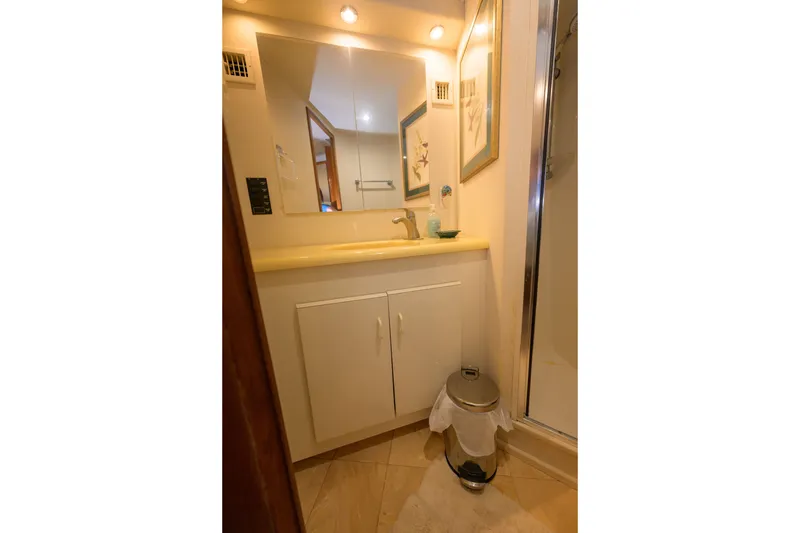 Slide: The Image of Bathroom interior of 1997 Viking 58 Enclosed Bridge yacht, featuring a mirror and sink. - 18