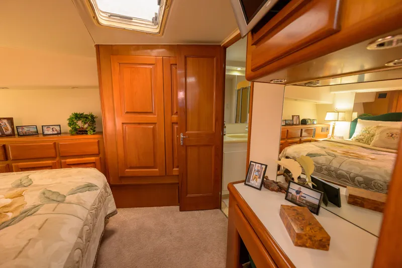 Slide: The Image of Luxurious 1997 Viking 58 Enclosed Bridge yacht bedroom with elegant wood finishes and cozy decor. - 12