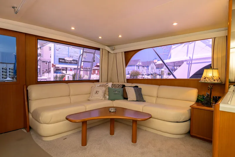 Slide: The Image of Luxurious interior of 1997 Viking 58 Enclosed Bridge yacht with plush seating and marina view. - 4