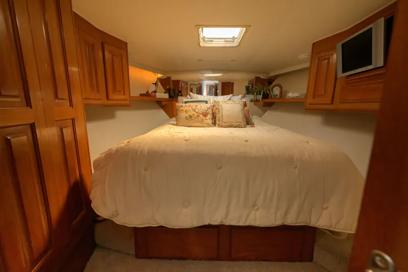 Slide: The Image of Luxurious bedroom interior of 1997 Viking 58 Enclosed Bridge yacht with cozy bedding. - 23