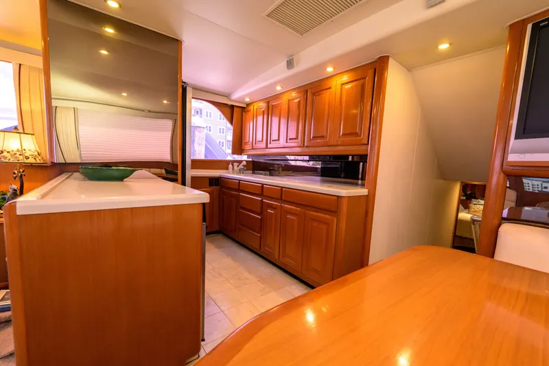 Slide: The Image of Interior of 1997 Viking 58 Enclosed Bridge yacht with wooden cabinetry and modern amenities. - 7