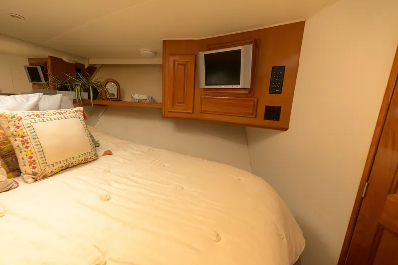Slide: The Image of Cozy bedroom in 1997 Viking 58 Enclosed Bridge yacht with TV and decorative pillows. - 22