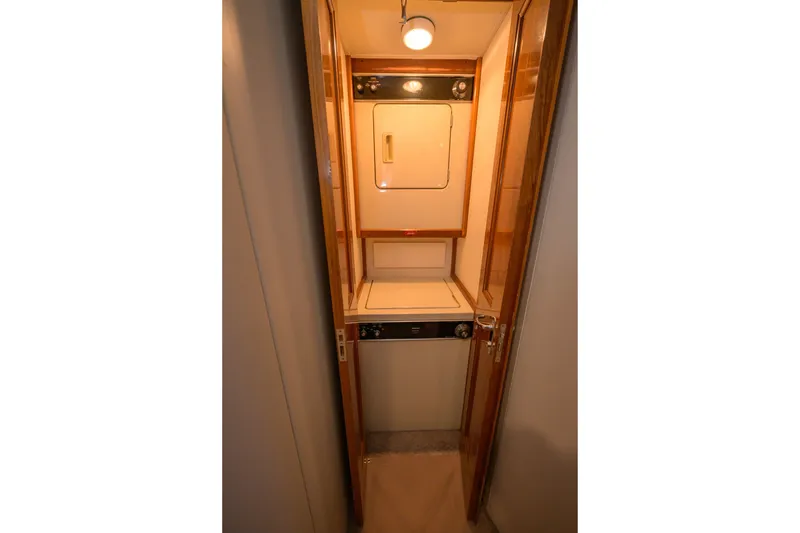 Slide: The Image of Laundry area inside 1997 Viking 58 Enclosed Bridge yacht, featuring washer and dryer. - 21