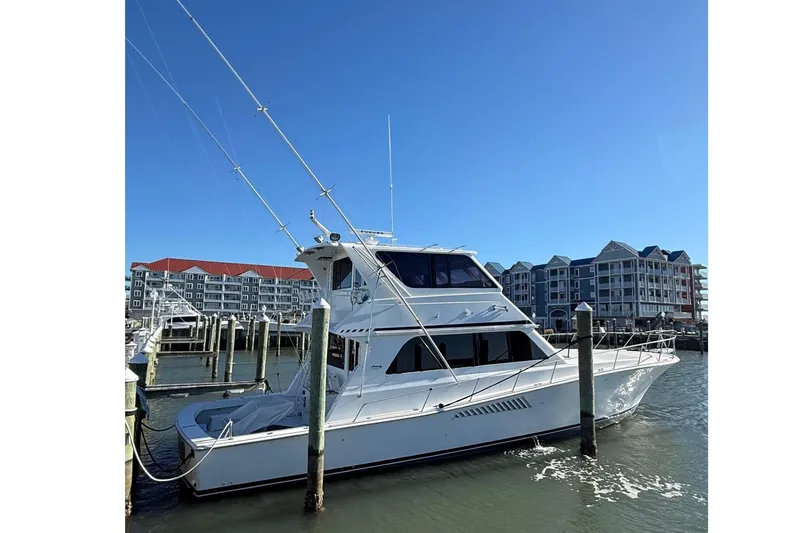 Slide: The Image of 1997 Viking 58 Enclosed Bridge yacht docked at marina, clear blue sky background. - 2