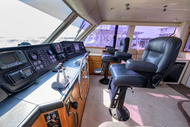 Slide: The Image of Interior of 1997 Viking 58 Enclosed Bridge yacht with helm and leather seating. - 27