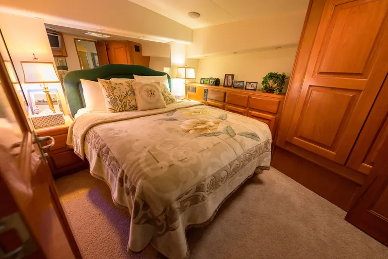 Slide: The Image of Luxurious bedroom interior on a 1997 Viking 58 Enclosed Bridge yacht, featuring elegant wood finishes. - 13