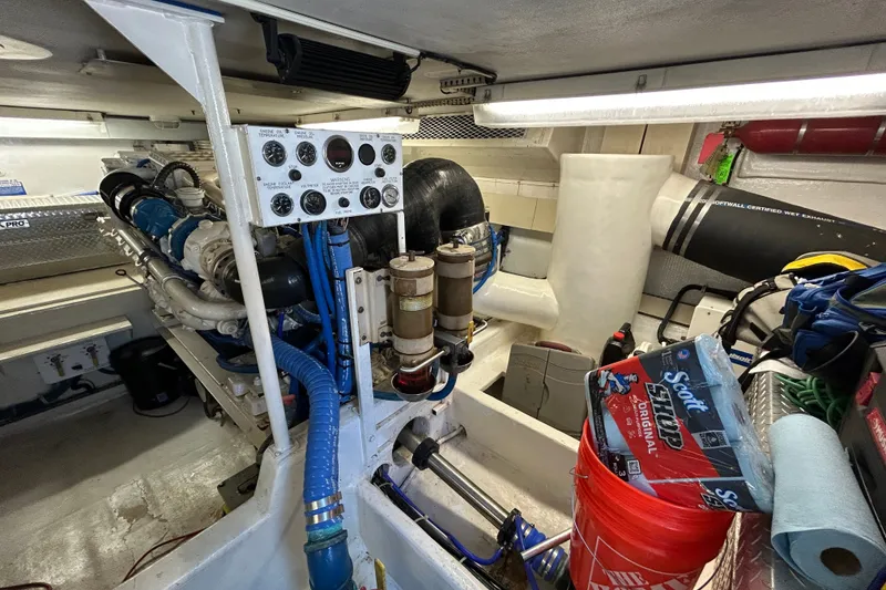 Slide: The Image of Engine room of a 1997 Viking 58 Enclosed Bridge yacht, featuring mechanical components and supplies. - 31