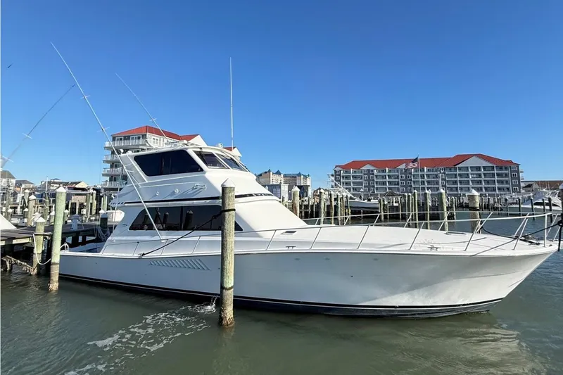The Image of 1997 Viking 58 Enclosed Bridge yacht docked at marina with buildings in background. - 1