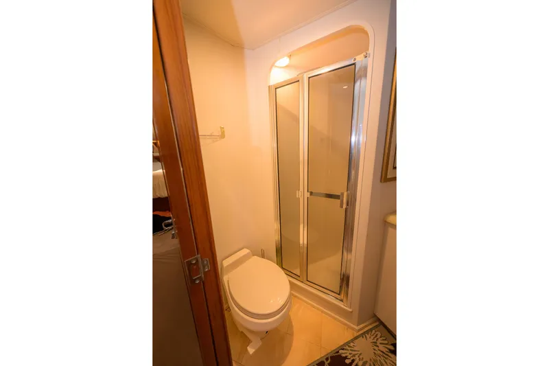 Slide: The Image of Bathroom interior of 1997 Viking 58 Enclosed Bridge yacht, featuring shower and toilet. - 19