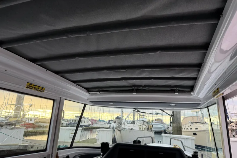 Slide: The Image of Interior view of 2021 Axopar 28 Cabin boat with marina background. - 22