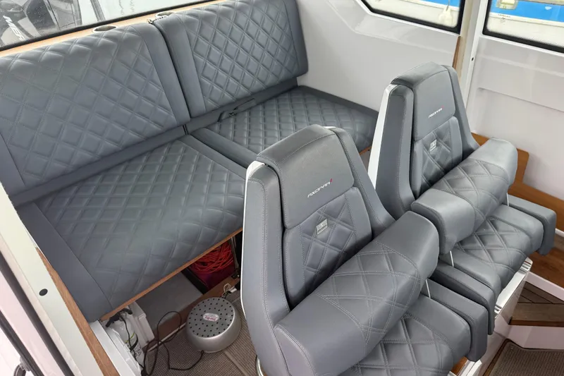 Slide: The Image of 2021 Axopar 28 Cabin interior with quilted gray seating and modern design. - 23