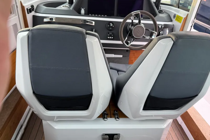 Slide: The Image of Interior of 2021 Axopar 28 Cabin boat, featuring dual seats and steering console. - 24